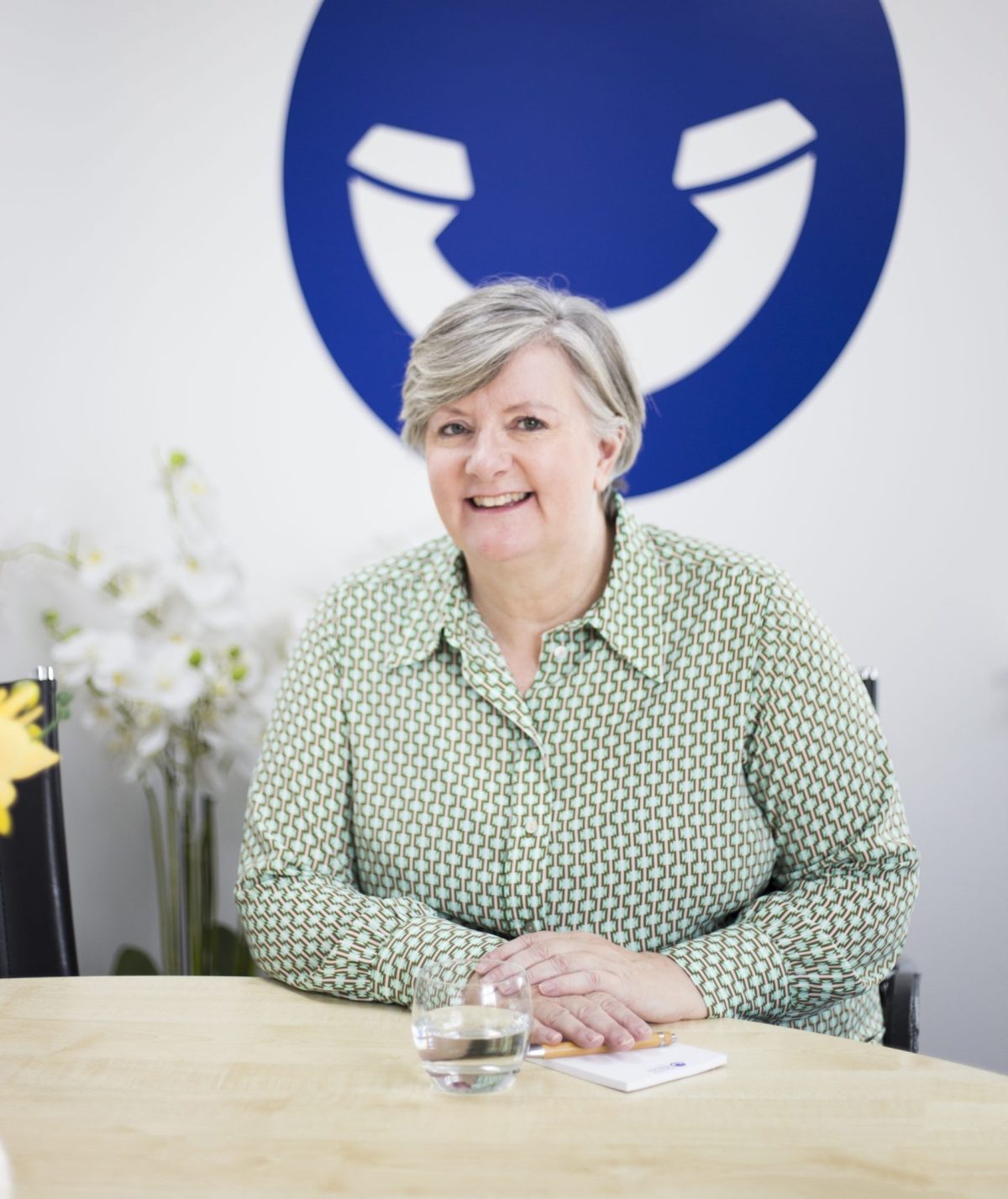 A smiling telephone answering service call handler, ready to take a call
