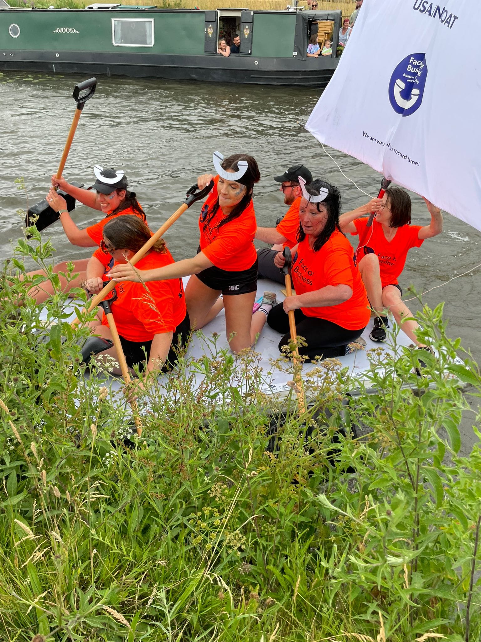 Face For Business team members on a raft for a charity race