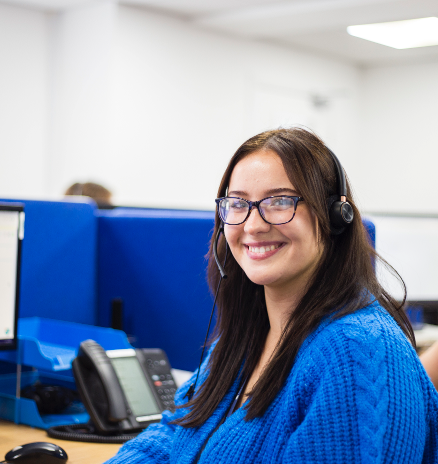 A smiling call answering PA wearing a headset